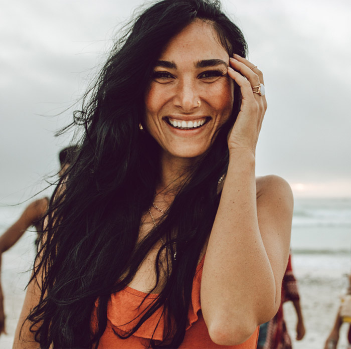 smiling woman with friends on the beach